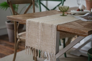 Detail of Nordic jacquard table runner with geometric weaving and decorative tassels