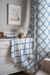 Detail of blue geometric print fabric with fringe tassels in a cozy home setting