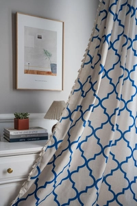 Detail of blue clover geometric print on linen curtain with light tassel fringe edge