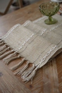 Close-up of beige jacquard table runner with fringe tassel and Nordic geometric patterns