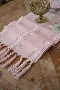 Detailed view of Nordic pink jacquard table runner with white embroidery and soft tassels