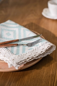 Macro detail of Nordic geometric orange table runner with lace edge and woven pattern