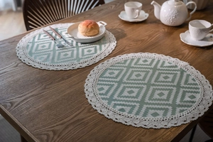 Close-up of bohemian style woven table mats with geometric patterns and white lace edges