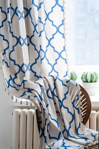 Detailed close-up of blue lattice print cotton curtain with decorative off-white tassels