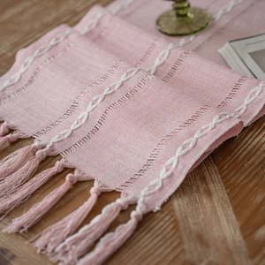 Pink Nordic geometric table runner with intricate hollow lace and tassel details