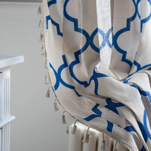 Blue geometric diamond print curtains with tassel fringe in a bohemian linen style