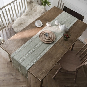 Nordic style sage green table runner with white geometric embroidery and tassels