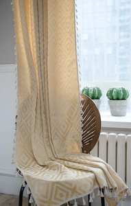 Detail of yellow geometric diamond jacquard curtain with white tassel fringe decoration