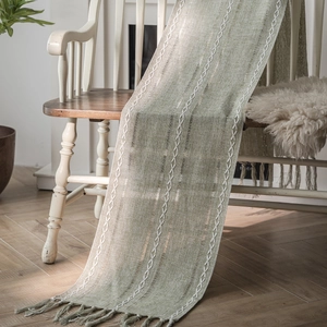 Nordic sage green woven table runner with white geometric diamonds and tassels