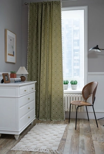 Detailed texture of green and beige geometric curtain fabric with elegant white tassels