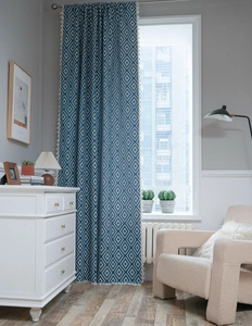 Detail of blue and beige geometric diamond pattern curtain with elegant tassel edges