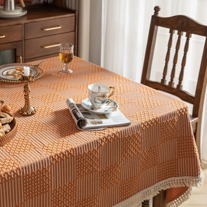 Detail der orangefarbenen Jacquard-Tischdecke mit weißen Quasten in Wohnumgebung