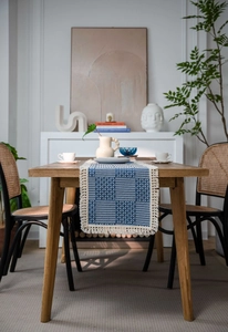 Detail of navy blue and beige geometric jacquard table runner with delicate fringe edge