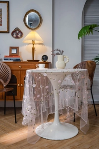 Detail of light pink floral embroidery on sheer mesh tablecloth for elegant home decor