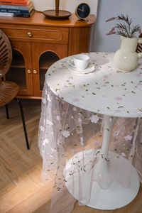 Detail of white mesh lace tablecloth with 3D pink floral embroidery and soft drape effect