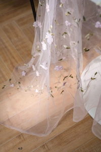 Detail of pink floral embroidery on white tulle fabric for elegant table decor