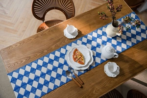 Close-up of blue and white geometric diamond woven table runner with tassel texture