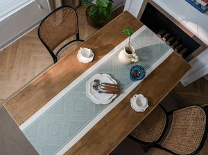 Detail showing Nordic blue geometric diamond weave pattern on a premium table runner