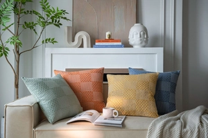 Macro detail of geometric textured weave on colorful square cushion covers in a cozy room