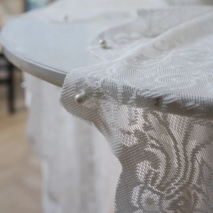 White embroidered lace tablecloth with delicate floral patterns and pearl bead accents