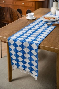 Detailed close-up of blue and white geometric rhombus cotton table runner with fringe