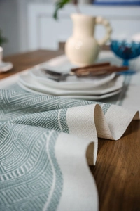 Close-up of geometric jacquard table runner fabric texture with green diamond pattern