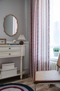 Close-up of bohemian cotton linen curtain featuring geometric stripes and white tassels