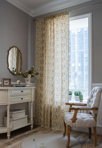 Detail of floral print curtains with decorative white tassels and cotton linen texture
