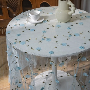 White lace round tablecloth with 3D blue floral embroidery and green vine details