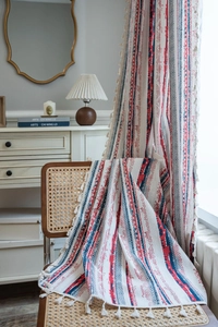 Close-up of bohemian cotton linen curtain with red blue geometric print and tassels