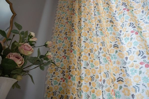 Detail view of floral print cotton linen curtain with elegant white tassel trim