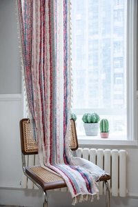 Close-up of cotton linen striped curtain with geometric patterns and fringe detail