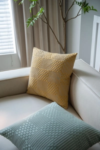 Detailed view of yellow and blue jacquard geometric patterns on thick woven cushions