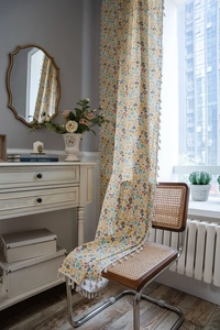 Detail of floral printed cotton linen curtain featuring delicate cream tassel fringe trim