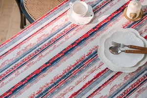 Detail der rot-blauen geometrischen Muster auf strukturiertem Vintage-Leinen-Tischtuch