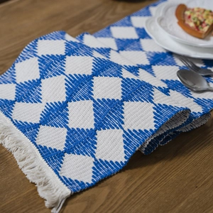 Blue and white geometric diamond woven table runner with decorative fringe tassels