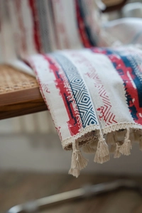 Detail of bohemian cotton linen curtain fabric featuring red and blue geometric patterns