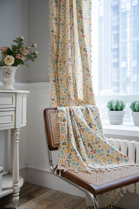Detail view of floral print curtains with decorative beige tassels in country style