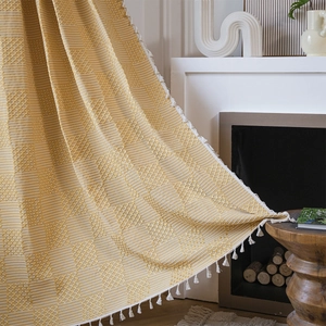 Yellow textured knit throw blanket with honeycomb pattern and elegant white tassels
