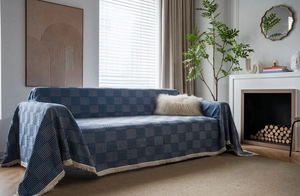 Detail of navy blue geometric jacquard sofa cover with cream white fringe tassels
