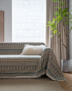 Dettaglio del copridivano jacquard bohémien rosso con frange decorative bianche