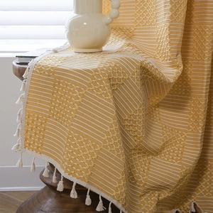 Ginger yellow woven throw with geometric jacquard patterns and cream tassel edges