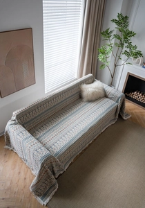 Dettaglio della trama geometrica bohémien e delle nappe decorative del copridivano