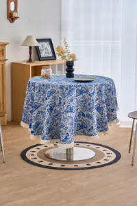 Close-up of the vintage blue floral tablecloth with white fringe and butterfly motifs