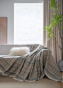 Dettaglio della coperta jacquard bohémien con motivi geometrici e rifiniture di frange