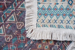 Dettaglio del copridivano jacquard rosso etnico con trama spessa e frange bianche