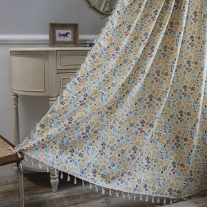 Floral print cotton linen curtain with white pom-pom fringe in a cozy vintage room