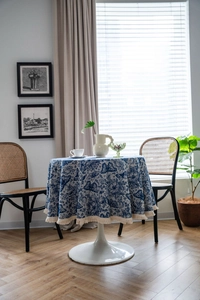 Detailed blue Toile de Jouy floral pattern on round tablecloth with fringe edges