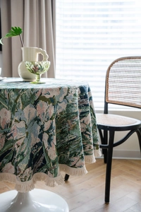 Close-up of thick green jacquard floral round tablecloth with detailed tassel fringe