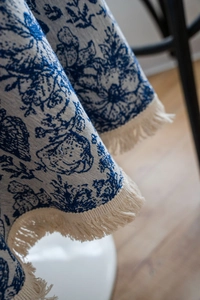 Detail of floral jacquard tablecloth with fringe edges and premium fabric texture